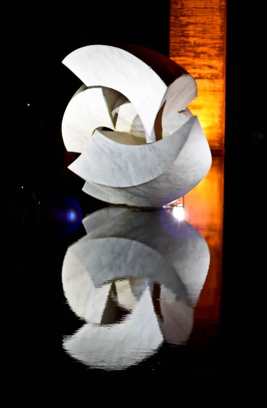 Escultura branca e seu reflexo no Palácio do Itamaraty à noite