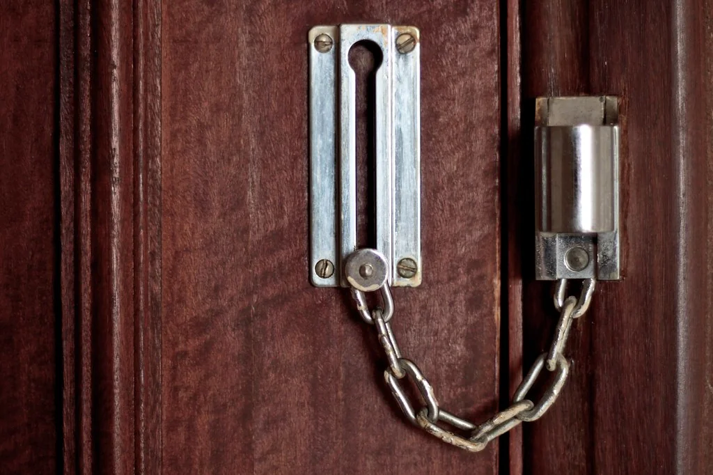 Fechadura e corrente numa porta de madeira escura