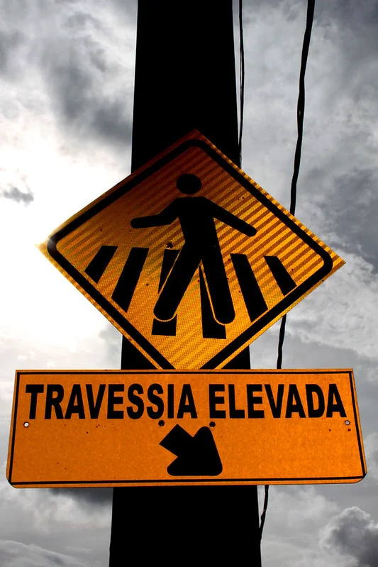 Placa laranja de travessia elevada fotografada contra o céu